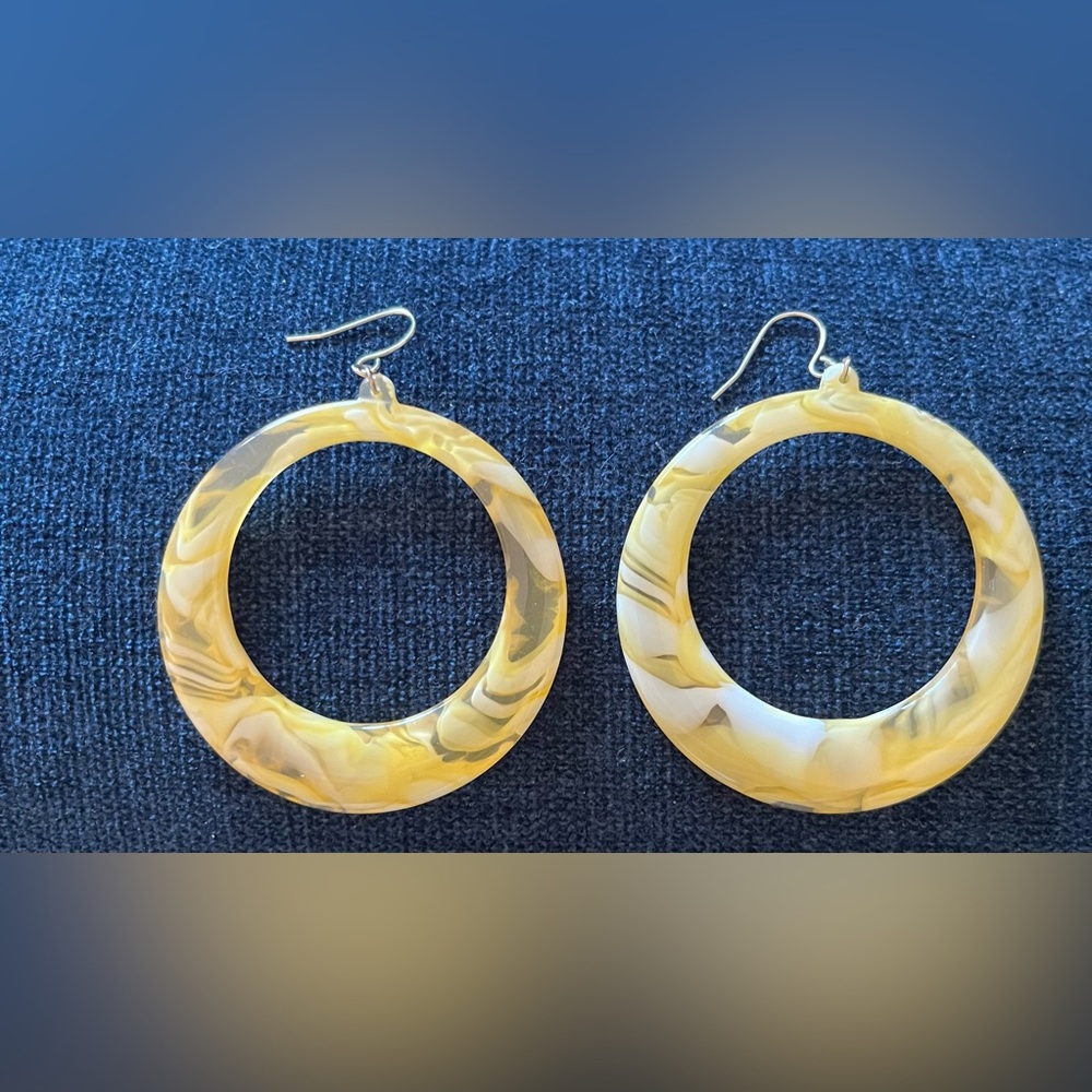 Yellow marbled hoop earrings, likely made of resin or acrylic.